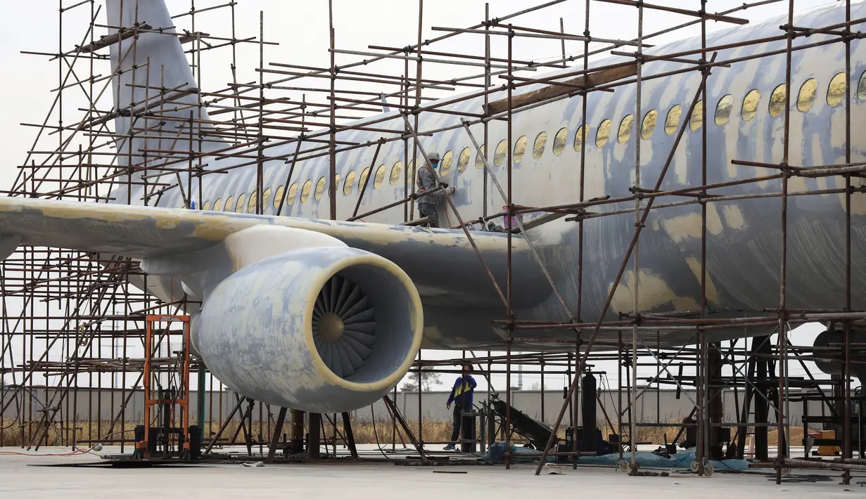 Seorang pria menyelesaikan replika pesawat Airbus A320 skala penuh di Kaiyuan, timur laut China, 25 Oktober 2018. Untuk membuat replika pesawat itu, petani bernama Zhu Yue menggunakan uang tabungannya lebih dari 2.6 juta yuan atau Rp 5,7 miliar. (STR/AFP)