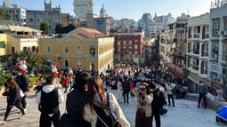 Pelancong dari China daratan berkumpul dekat Reruntuhan St. Paul's, tujuan wisata di Makau, 18 Januari 2022. Ledakan pariwisata China yang diharapkan selama liburan Tahun Baru Imlek minggu depan tampaknya akan lebih cepat terjadi. (AP Photo/Kanis Leung)