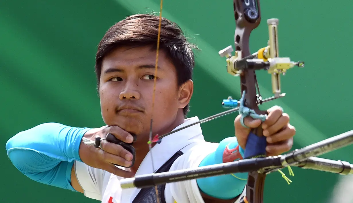 Pemanah putra Indonesia, Riau Ega Agatha berlaga melawan pemanah Korsel, Kim Woo-jin pada babak penyisihan Olimpiade 2016, di Rio de Janeiro, Senin (8/8). Ega mengalahkan pemanah yang juga merupakan nomor satu dunia itu dengan skor 6-2. (Jewel SAMAD/AFP)