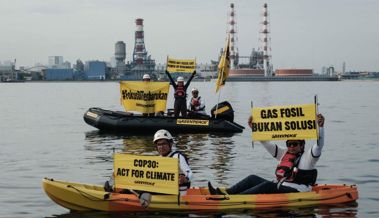 Mereka menyerukan penghentian ketergantungan pada bahan bakar fosil. Tampak dalam foto, aktivis Greenpeace Indonesia melakukan aksi di kawasan perairan depan Pembangkit Listrik Tenaga Gas Uap (PLTGU) Muara Karang, Jakarta pada Selasa 18 November 2025. (YASUYOSHI CHIBA/AFP)