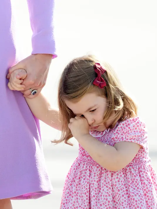 Putri Charlotte saat merajuk dalam kunjungan bersama orangtuanya, Pangeran William dan Kate Middleton ke Pabrik Airbus di Hamburg, Jerman, 21 Juli 2017. Putri Charlotte mendadak merajuk dan enggan naik helikopter di pabrik pesawat terbang itu. (AP Photo)