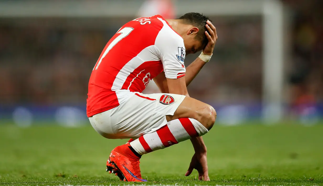 Penyerang Arsenal, Alexis Sanchez terlihat sedih usai timnya dikalahkan saat Laga Liga Premier Inggris di Emirates Stadium, Selasa (12/5/2015). Swansea City menang 1-0 atas Arsenal. (Reuters/Andrew Couldridge)
