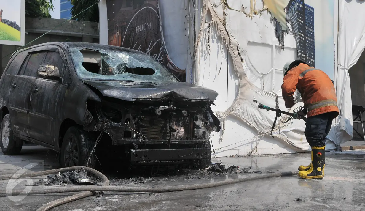 Petugas saat memadamkan sisa api kebakaran mobil di area SPBU Jalan Gatot Subroto, Jakarta, Selasa (1/9/2015). Sumber api diduga berasal dari sebuah drum yang berada di dekat tangki pengisian BBM di SPBU tersebut. (Liputan6.com/Herman Zakharia)