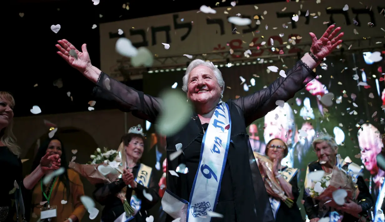 Rita Berkowitz (83) merayakan kemenangannya saat kontes kecantikan Miss Holocaust Survivor di Israel, Selasa (24/11). 13 wanita lansia mengikuti kontes kecantikan tahun ketiga yang diperuntukkan bagi korban selamat genosida Nazi. (REUTERS/Amir Cohen)