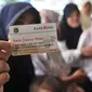 Warga menunjukkan Kartu Jakarta Pintar (KJP) di Pasar Blok G Tanah Abang, Jakarta, Selasa (11/12). Warga sangat antusias memanfaatkan KJP untuk membeli sembako murah karena harga yang lebih murah dari pasar. (Merdeka.com/Iqbal S. Nugroho)