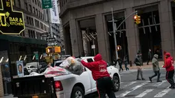 Pekerja mamasukan sampah ke truk di Lower Manhattan di New York City (22/2). Dengan menggunakan data dari Environmental Protection Agency memberi peringkat New York City sebagai kota paling kotor di negara tersebut. (AFP Photo/Drew Angerer)