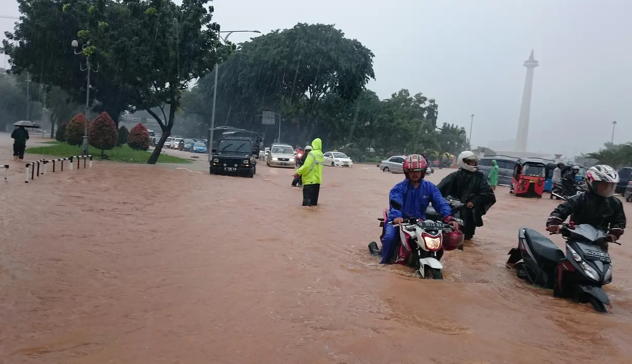 Sejumlah kendaraan nekat melintasi jalan di depan istana Negara yang terendam banjir, Jakarta, Senin (9/2/2015).(Antara Foto/Fanny Octavianus)
