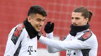 Gelandang Bayern Munchen, Marcel Sabitzer (kanan) bercanda dengan rekan setimnya Marc Roca selama sesi latihan di Munich, Jerman, Selasa (5/4/2022). Munchen akan bertanding melawan Villarreal pada leg pertama perempat final Liga Champions. (AFP/Christof Stache)