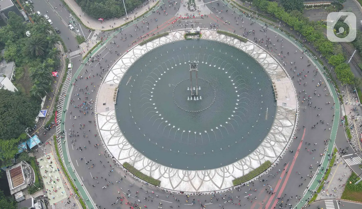 Foto udara aktivitas warga di kawasan Bundaran HI, Menteng, Jakarta Pusat, Minggu (22/5/2022). Pemprov DKI Jakarta kembali menggelar Hari Bebas Kendaraan Bermotor (HBKB) di sejumlah ruas jalan Ibu Kota. HBKB yang digelar pukul 06.00 – 10.00 tersebut dalam rangka meningkatkan kualitas udara di Jakarta. (Liputan6.com/Herman Zakharia)