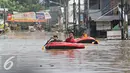Warga menaiki perahu karet saat banjir melanda kawasan Perumahan Pondok Gede Permai, Bekasi, Jawa Barat, Kamis (21/4). Banjir dengan ketinggian tiga meter yang berasal dari meluapnya Sungai Cikeas. (Liputan6.com/ Immanuel Antonius)