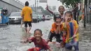 Sejumlah anak-anak bermain di lokasi banjir kawasan Jalan Pramuka, Jakarta, Minggu (1/2/2015). (Liputan6.com/Andrian M Tunay) 