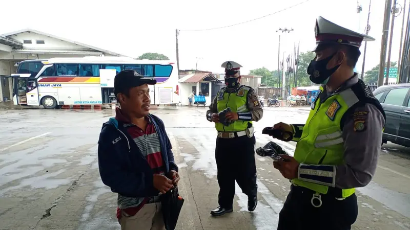 Aparat kepolisian memberikan masker gratis dan edukasi secara masif kepada para penumpang di pool bus Sinar Jaya, Jalan Inspeksi Kalimalang, Desa Suka Danau, Cikarang Barat, Kabupaten Bekasi, Jawa Barat