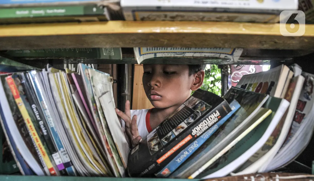 Seorang anak mencari buku untuk dibaca di perpustakaan Bale Buku Meleduk (Membaca Literasi Dukuh) 75 di Jalan Dukuh V, Kelurahan Dukuh, Kecamatan Kramat Jati, Jakarta Timur, Rabu (24/8/2022). Selain itu, gerakan Hanjaba juga sebagai upaya mewujudkan generasi yang cinta membaca dan cinta perpustakaan. (merdeka.com/Iqbal S. Nugroho)
