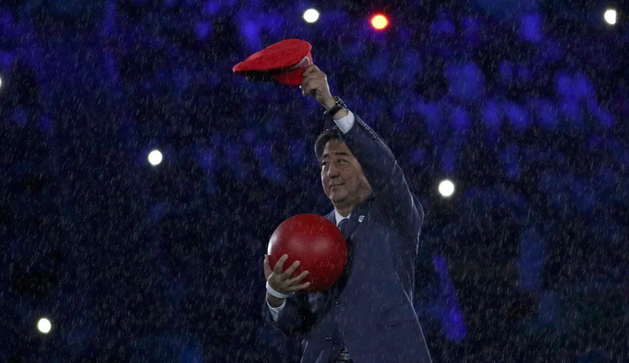 PM Jepang, Shinzo Abe terlihat di atas panggung pada upacara penutupan Olimpiade Rio 2016 di stadion Maracana, Rio de Janeiro, Minggu (21/8). Shinzo Abe sempat menyamar menjadi Mario Bros untuk mempromosikan Olimpiade Tokyo 2020. (Stoyan Nenov/AFP)