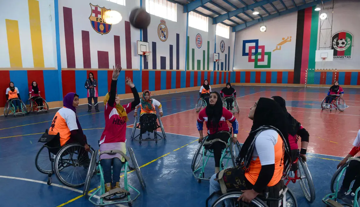  Tim Kahkashan (orange) dan tim Sitara (merah) beraksi pada Turnamen Basket Kursi Roda untuk penyandang cacat di Provinsi Herat, Afghanistan, Minggu (29/11/2015). (AFP Photo/Aref Karimi).