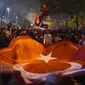 Pendukung Presiden Recep Tayyip Erdogan merayakan di luar markas Partai Keadilan dan Pembangunan ( AKP) di Istanbul, Turki, Minggu (14/5/2023). (AP Photo/Khalil Hamra)