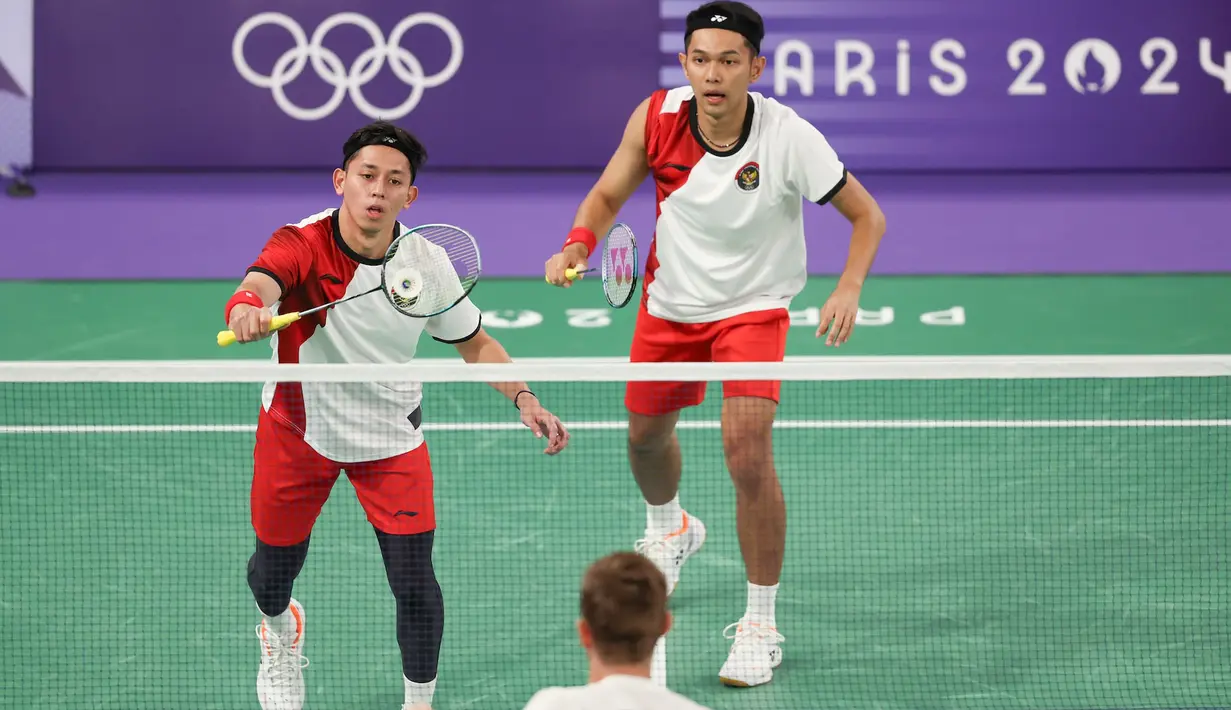 <p>Pemain ganda putra Indonesia, Muhammad Rian Ardianto (kiri) mengembalikan bola serve saat menghadapi wakil Prancis, Lucas Corvee/Ronan Labar pada laga Grup C Olimpiade Paris 2024 di Porte De La Chapelle Arena, Paris, Senin (29/7/2024). Fajar Alfian/Muhammad Rian Ardianto menang dua gim langsung 21-13, 21-10. (Dok. NOC Indonesia/Naif Muhammad Al'as)</p>