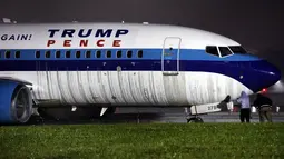 Petugas memeriksa pesawat yang membawa pasangan Capres AS Donald Trump, Mike Pence di landasan Bandara LaGuardia, New York, Kamis (27/10). Pesawat jenis Boeing 737 itu mendarat saat hujan lebat melanda wilayah tersebut. (REUTERS/Lucas Jackson)