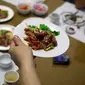 Pramusaji menyajikan hidang dari daging anjing di restoran khusus anjing, Pyongyang House of Sweet Meat, di Korea Utara, Rabu (25/7). Dikenal dengan nama dangogi, daging anjing banyak dikonsumsi oleh masyarakat Korea saat cuaca panas. (AP/Dita Alangkara)