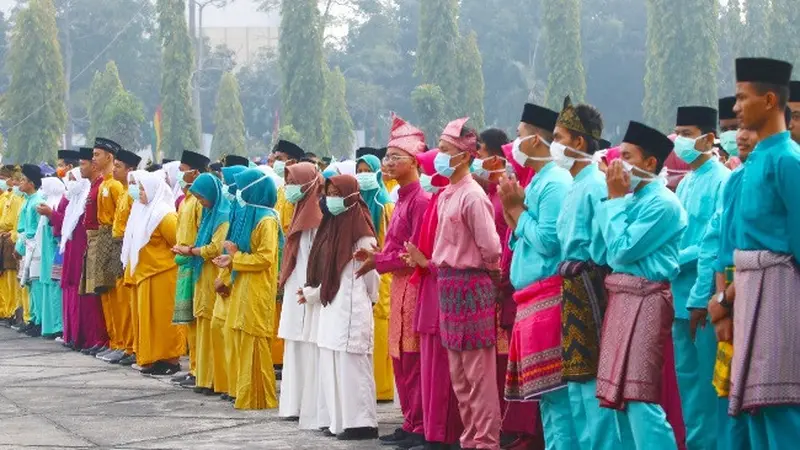 Pelajar peserta upacara HUT Riau memakai masker karena kabut asap menyelimuti Pekanbaru.