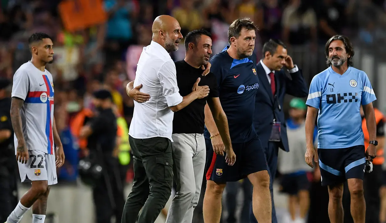 Manajer Manchester City, Pep Guardiola (kiri) memeluk pelatih Barcelona Xavi Hernandez pada akhir sebuah laga amal di Stadion Camp Nou, Kamis (25/8/2022) dinihari WIB. Laga ini berlangsung menarik karena mempertemukan sang guru dan murid yaitu Pep Guardiola selaku pelatih Man City dan Xavi Hernandes pelatih Barcelona. (Photo by Josep LAGO / AFP)