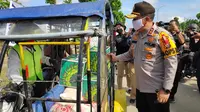 Kapolda Riau Irjen Agung Setya Imam Effendi berbincang dengan pengemudi becak motor yang mengantarkan sembako kepada masyarakat terdampak Covid-19 di Pelalawan. (Liputan6.com/M Syukur)