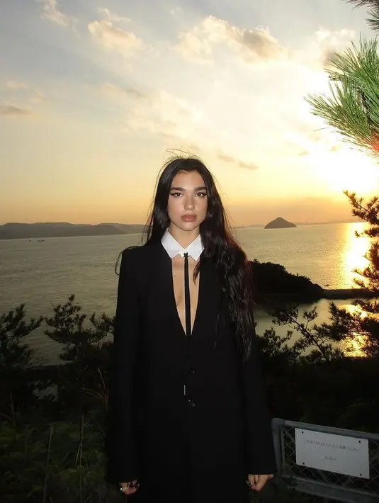 Melengkapi penampilannya, Dua Lipa mengenakan collar putih dan platform shoes berwarna hitam. [instagram/dualipa]