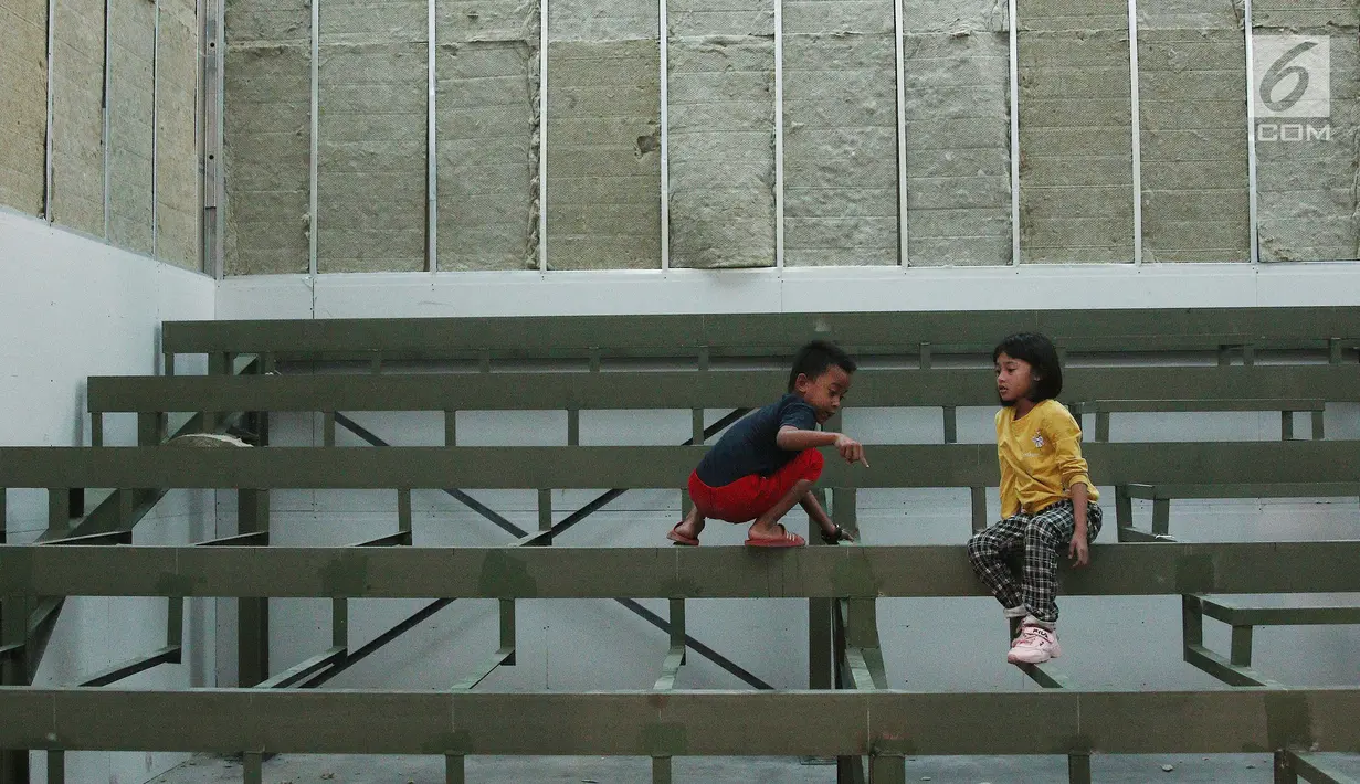 Anak-anak bermain dalam ruang bioskop rakyat di Pasar Jaya Teluk Gong, Jakarta, Sabtu (24/11). Bioskop rakyat ini dibangun di atas gedung Pasar Jaya Telok Gong. (Liputan6.com/Herman Zakharia)
