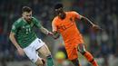 Gelandang Belanda, Quincy Promes, beradu cepat dengan gelandang Irlandia Utara, Stuart Dallas, pada laga Kualifikasi Piala Eropa 2020 di Windsor Park, Belfast, Sabtu (16/11). Kedua negara bermain imbang 0-0. (AFP/Mark Marlow)