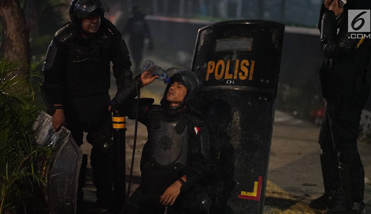 Personel Kepolisian dari satuan Brimob membasuh wajah di sela-sela tugas menghalau massa yang berlaku anarkis di sekitar depan Gedung Bawaslu, Jalan MH Thamrin, Jakarta, Rabu (22/5/2019).
Aksi unjuk rasa yang dimotori GNKR berakhir ricuh. (Liputan6.com/Immanuel Antonius)