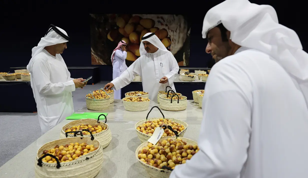 Para juri mendiskusikan kualitas kurma selama Festival tahunan Kurma Liwa  di kota Liwa, Abu Dhabi pada Rabu (17/7/2019). Festival Kurma Liwa juga menawarkan begitu banyak pengunjung muda untuk belajar, tentang sejarah pohon kurma dan keaslian budaya Arab.  (AP Photo/Kamran Jebreili)