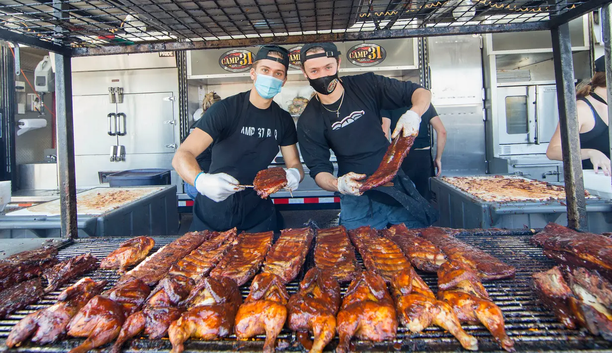 Para koki berpose bersama iga bakar olahan mereka dalam acara drive-thru Scarborough Ribfest 2020 di Toronto, Kanada, pada 27 September 2020. Pengunjung festival makanan yang digelar dalam format drive-thru itu dapat memesan makanan dari penjual di lokasi dan membawanya pulang. (Xinhua/Zou Zheng)