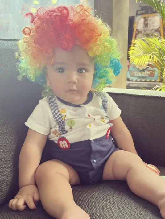 Mama Gigi memang pintar mendandani Rayyanza hingga menjadi lucu. Seperti saat Rayyanza memakai wig warna-warni yang identik digunakan badut. Foto Rayyanza yang lucu banget ini banjir like dan komentar dari netizen. (Liputan6.com/IG/raffinagita1717)