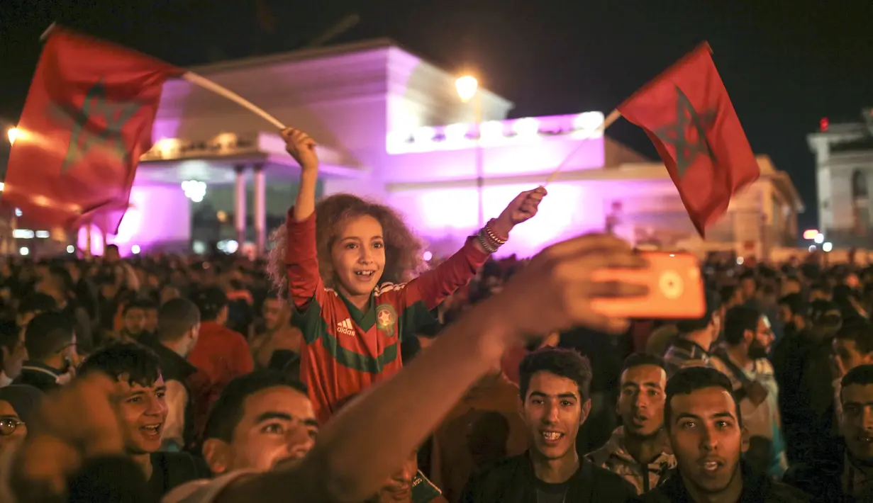 Seorang anak ikut berpesta merayakan keberhasilan negaranya lolos ke Piala Dunia 2018 di Rabat, Sabtu (11/11/2017). Maroko lolos setelah mengalahkan Pantai Gading 2-0 pada laga penentu. (AP/Mosa'ab Elshamy)