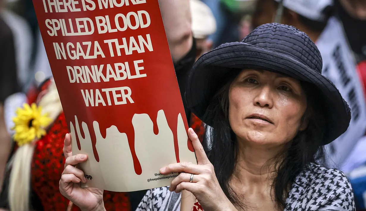 Sementara itu, sebuah studi terbaru yang diterbitkan jurnal medis The Lancet Global Health mengungkap, jumlah korban tewas di Gaza selama 15 bulan pertama operasi militer Israel sejak Oktober 2023 mencapai lebih dari 75.000 orang. Tampak dalam foto, para demonstran pro-Palestina membawa bendera, spanduk, dan plakat saat mereka berbaris berunjuk rasa di jalanan kota Sydney, Australia, Minggu 22 Februari 2026. (DAVID GRAY/AFP)