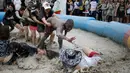 Sejumlah turis mengikuti sebuah permainan dalam Festival lumpur Boryeong di pantai Daecheon, Boryeong, Korea Selatan, (15/7). Festival lumpur Boryeong selalu mengadakan berbagai perlombaan yang menggunakan arena berlumpur. ( REUTERS/Kim Hong-Ji)