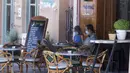 Pengunjung mengenakan masker duduk di kafe di pelabuhan Pulau Poros, Yunani 7/8/2020). Terus bertambahnya jumlah kasus terkonfirmasi coronavirus di beberapa wilayah Yunani memaksa pihak berwenang memberlakukan jam malam pertama selama musim pariwisata di Pulau Poros. (Xinhua/Marios Lolos)