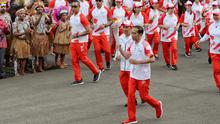 Presiden Joko Widodo didampingi Menpora Imam Nahrawi membawa api obor Asian Games 2018 sebelum upacara penurunan Bendera Merah Putih di Istana Negara Jakarta, Jumat (17/8). (Liputan6.com/Pool/Eko)