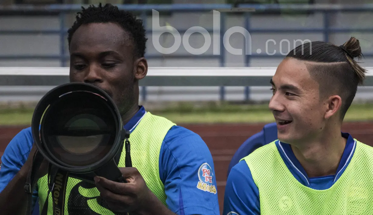Gelandang Persib Bandung, Kim Kurniawan, tertawa melihat Michael Essien mencoba menggunakan kamera sebelum laga uji coba melawan Bali United di Stadion GBLA Bandung, Jawa Barat, Sabtu (8/4/2017). (Bola.com/Vitalis Yogi Trisna)