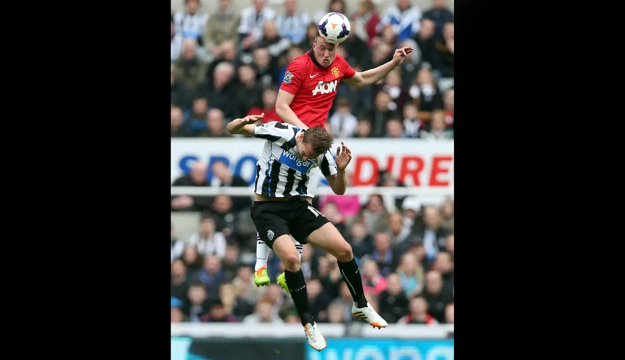 Pemain Manchester United, Phil Jones (atas), berebut bola dengan pemain Newcastle United, Luuk de Jong, dalam pertandingan lanjutan Liga Inggris 2013/2014 di St James' Park, Sabtu (5/4/2014). (AFP/Ian MacNicol)