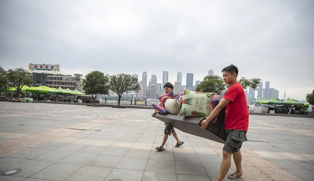 Pedagang yang tinggal di dekat tepi Sungai Yangtze memindahkan barang mereka ke tempat yang lebih aman di Jalan Nanbin, Kota Chongqing, China (18/8/2020). Kota Chongqing dilanda banjir parah. Status tanggap darurat Level I dikeluarkan pada Selasa (18/8) untuk pengendalian banjir. (Xinhua/Huang Wei)