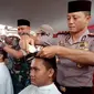 Nampak Kapolres Budi terlihat lihat memotong salah satu rambut salah satu anggota polres Garut, dalam penggalangan dana korban tsunami Selat Sunda siang tadi (Liputan6.com/Jayadi Supriadin)