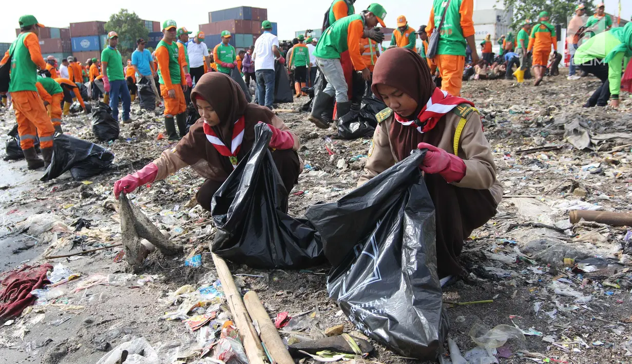 Siswa pramuka memasukan sampah ke dalam kantong saat melakukan Gerebek Sampah di Pesisir Teluk Jakarta, Cilincing, Jakarta Utara, Minggu (15/4). Kegiatan ini melibatkan 1.000 orang terdiri dari berbagai unsur masyarakat. (Liputan6.com/Arya Manggala)