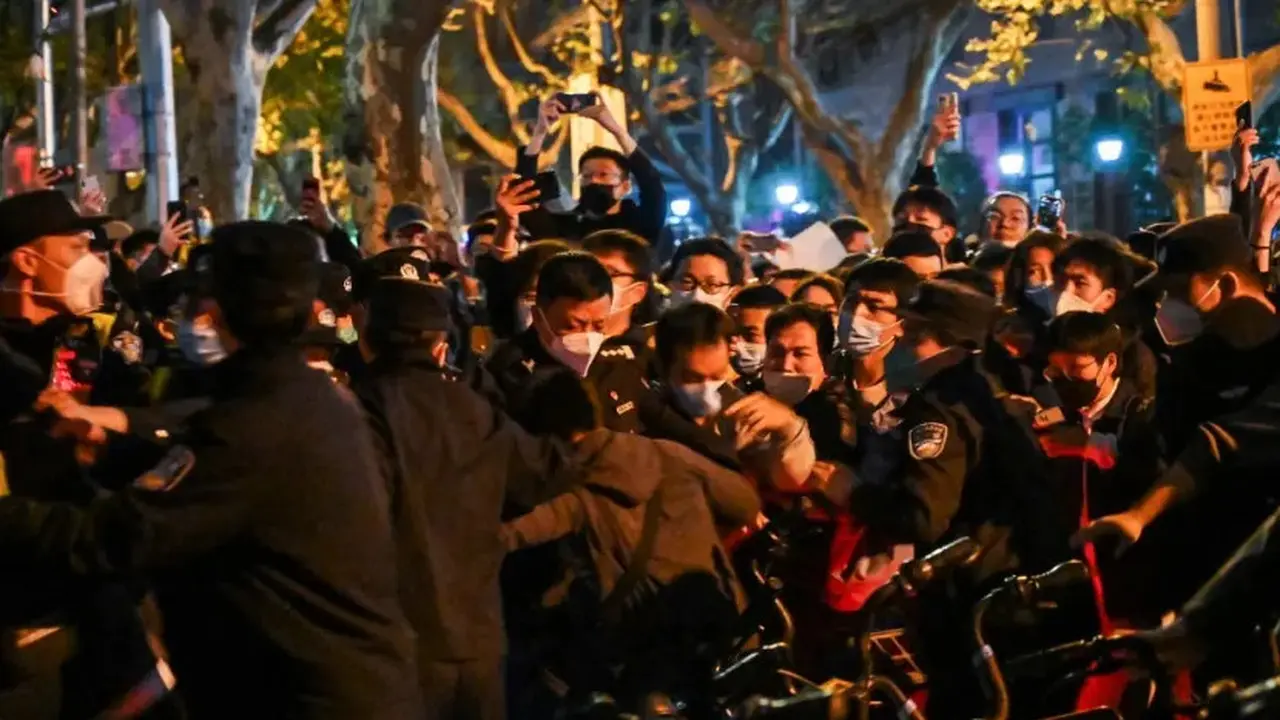Polisi dan demonstran bentrok di Shanghai pada 27 November 2022, di mana protes terhadap kebijakan nol-COVID China. (Foto: AFP/Hector Retamal)