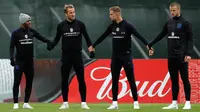 Pemain Inggris, Harry Kane, Raheem Sterling, Jordan Henderson dan Eric Dier berpegangan tangan selama latihan jelang menghadapi Kolombia pada babak 16 besar Piala Dunia 2018 di Spartak Zelenogorsk, St. Petersburg, Rusia, (2/7). (AP Photo / Alastair Grant)