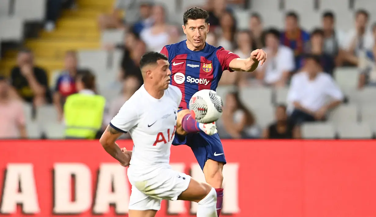 Pemain Barcelona, Robert Lewandowski (kanan) berebut bola dengan pemain Tottenham Hotspur, Pedro Porro pada laga Piala Joan Gamper edisi ke-58 di Estadi Olimpic Lluis Companys, Barcelona, 8 Agustus 2023. (AFP/Pau Barrena)