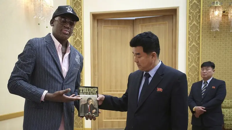 Mantan bintang NBA Dennis Rodman ketika menyerahkan buku kepada Menteri Olahraga Korut Kim Il Guk