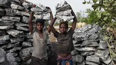  Bocah perempuan mengangkat bongkahan batu saat bekerja di sebuah tambang di Ouagadougou, Burkina Faso, 21 Desember 2015. 12 Juni ditetapkan sebagai Hari Penentangan Pekerja Anak Sedunia. (NABILA EL Hadad / AFP)