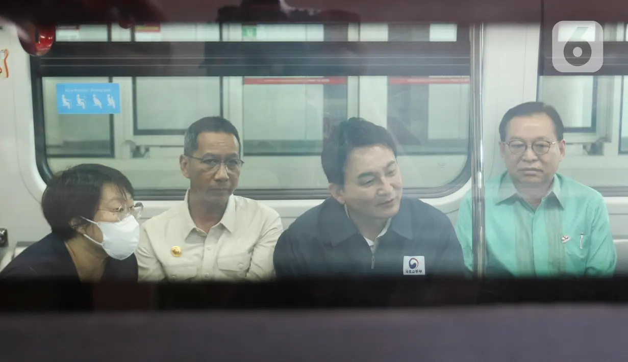 Heru Budi bersama Won Hee Ryong pun langsung masuk ke dalam gerbong LRT dan duduk berdampingan. (Liputan6.com/Herman Zakharia)