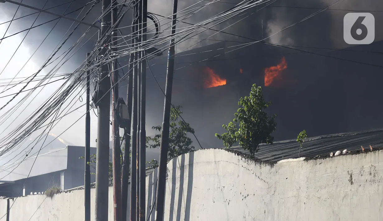 Asap hitam membumbung dari atas Gudang JNE Express yang terbakar di Jalan Pekapuran Raya, Depok, pada Senin (12/9/2022). Bahkan, asap bisa terlihat hingga wilayah Pasar Rebo, Jakarta Timur atau radius 10 km dari lokasi titik api. (Liputan6.com/Herman Zakharia)